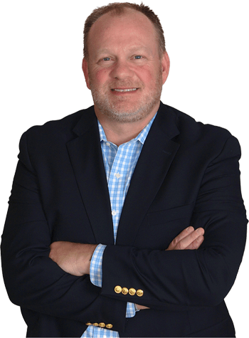 Michael J. Garry with arms crossed, wearing a dark blazer and a light blue checkered shirt