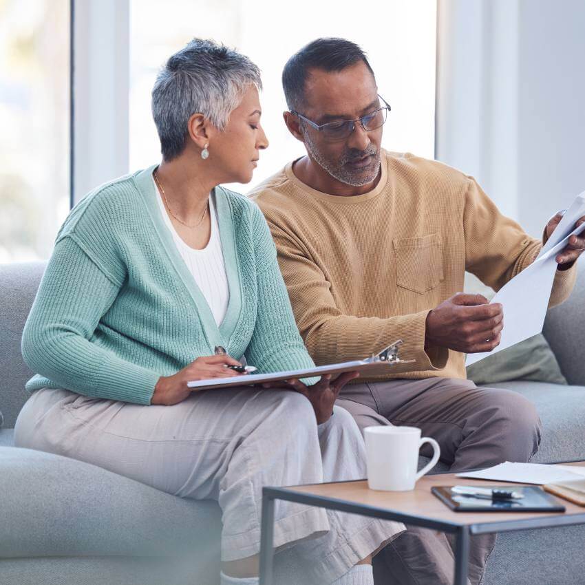 Older couple sitting at coffee table, going over retirement information