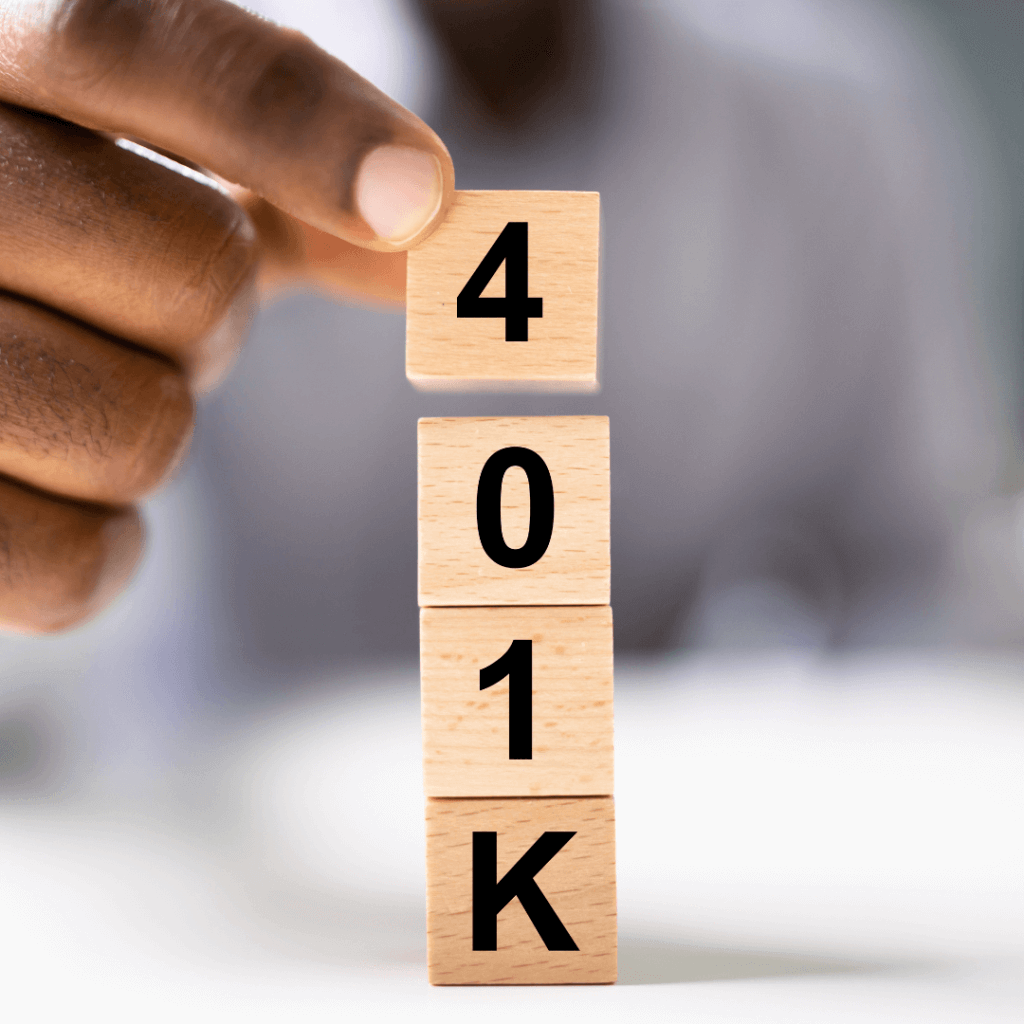 Close-up of a hand stacking wooden blocks spelling 401(k), representing unclaimed 401(k) accounts and financial planning.